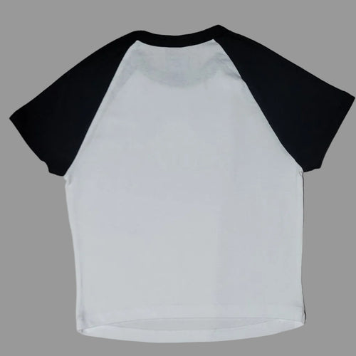 White long-sleeve shirt with black sleeves on a beige surface