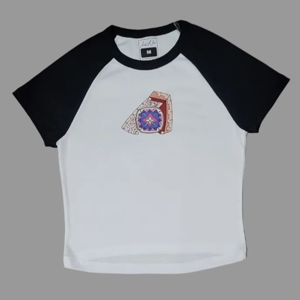 White t-shirt with black sleeves and a logo on a beige surface